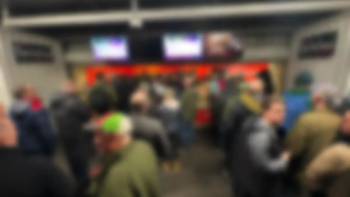 Crowd gathered at a busy stadium bar during a peak service period